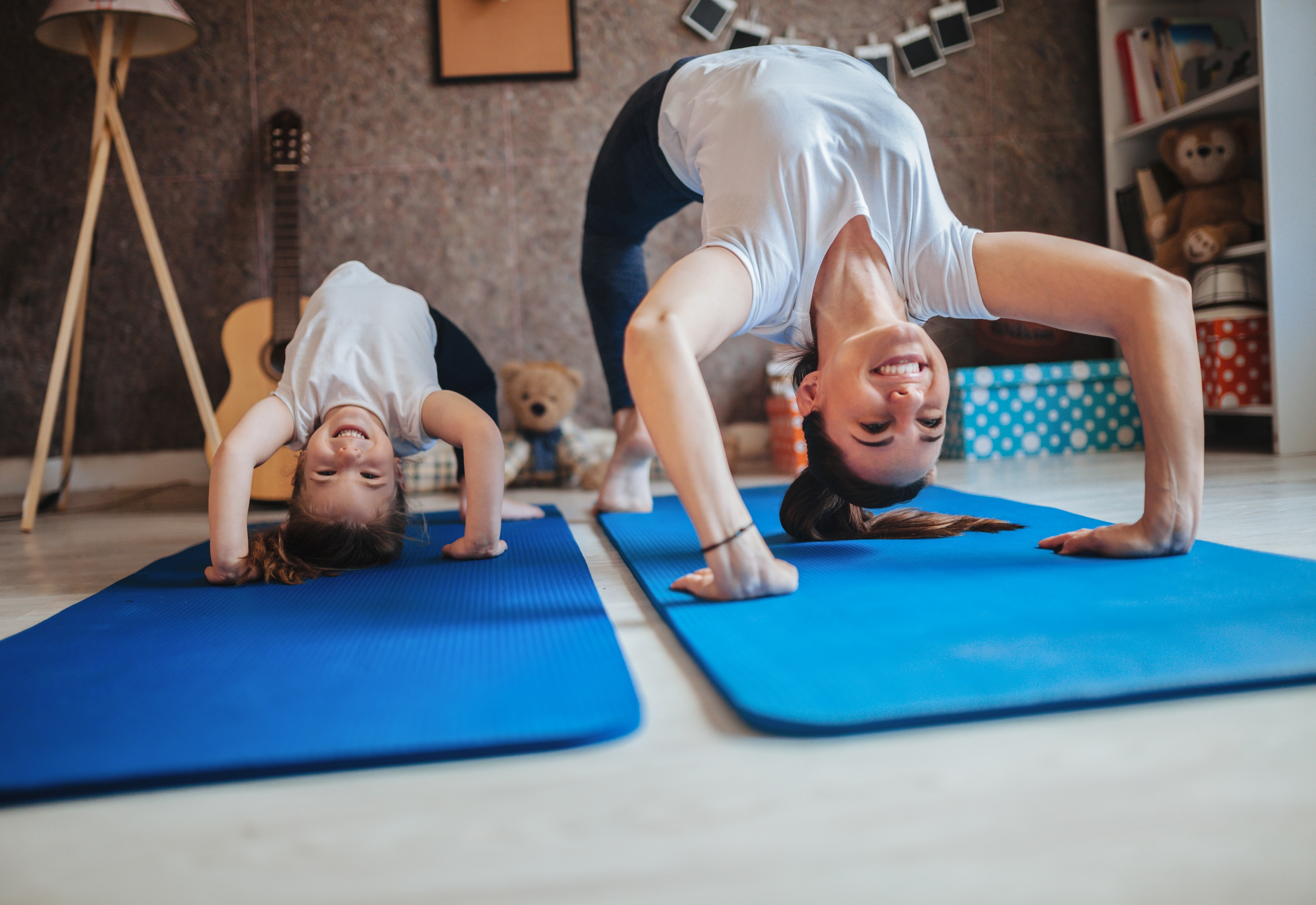 Oyun odasında birlikte yoga yapan bir anne ve kızı.